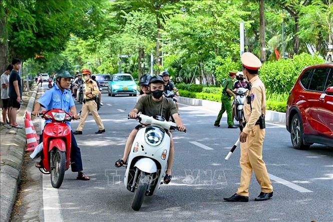 Một số người điều khiển xe máy cố tình tăng ga bỏ chạy khi phát hiện chốt kiểm tra, nhưng bị lực lượng chức năng kịp thời ngăn chặn. Ảnh: Trung Nguyên - TTXVN