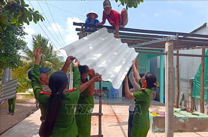Lực lượng Công an Cà Mau lợp lại mái nhà cho các hộ dân bị ảnh hưởng do dông lốc trong đợt nghỉ lễ Quốc khánh 2-9. Ảnh: TTXVN phát