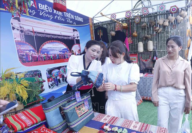 Du khách chọn mua sản phẩm dệt thổ cẩm của xã Quỳnh Nhai tại Tuần Văn hóa Du lịch Mộc Châu tỉnh Sơn La năm 2026. Ảnh: Quang Quyết - TTXVN