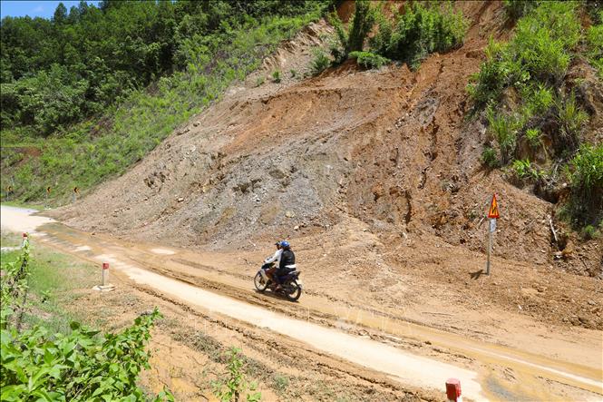 Phương tiện lưu thông trên Quốc lộ 48C đoạn qua khu vực dốc Pù Huột có taluy dương cao, dựng đứng và tiềm ẩn nguy cơ tiếp tục xảy ra sạt lở. Đây là những vị trí cần được theo dõi, cảnh báo và chủ động xử lý nhằm bảo đảm an toàn giao thông trong mùa mưa lũ. Ảnh: Xuân Tiến - TTXVN. 