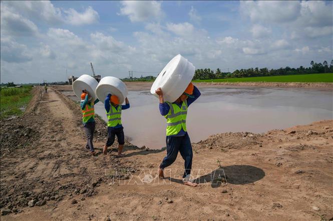 Công nhân vận chuyển vật liệu về công trường ở gói thầu số 1, dự án thành phần 2 cao tốc Châu Đốc - Cần Thơ - Sóc Trăng cuối tháng 8/2026. Ảnh: Thanh Liêm - TTXVN