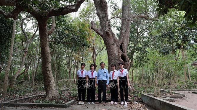 Ông Nguyễn Minh Việt, người gắn bó nhiều năm với Rừng cây Bác Hồ chia sẻ những câu chuyện lịch sử cách mạng với các em học sinh địa phương. Ảnh: Đỗ Trưởng – TTXVN