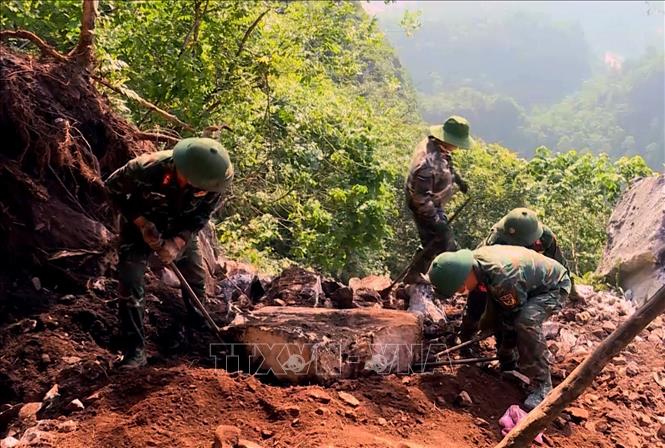 Đội quy tập hài cốt liệt sĩ dùng dụng cụ thô sơ cạy từng tảng đá, tìm kiếm hài cốt liệt sĩ tại Điểm cao 685. Ảnh: TTXVN phát