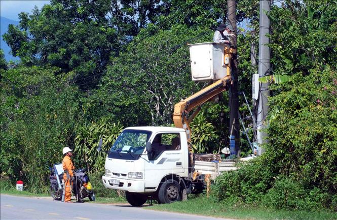 Cán bộ Công ty Điện lực Quảng Trị phối hợp cán bộ viễn thông Viettel triển khai rà soát, gia cố lưới điện trước mùa mưa bão. Ảnh: Tá Chuyên - TTXVN