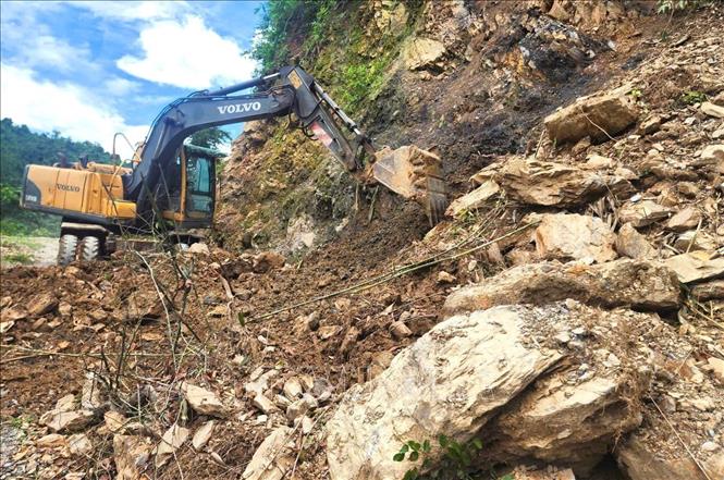 Máy móc san ủi, khai thông tuyến đường tại các điểm sạt lở lớn tại khu vực dốc Nứa, Co Pọng, Xốp Na, Pu Pà Hịa và Co Ngóa. Ảnh: TTXVN phát