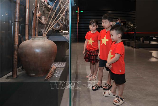 Trẻ mầm non mặc đồng phục cờ đỏ sao vàng đến tham quan Bảo tàng Lịch sử Quân sự Việt Nam. Ảnh: Phan Phương – TTXVN