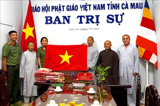 Công an Cà Mau trao tặng quốc kỳ cho các tổ chức cơ sở tôn giáo trên địa bàn tỉnh. Ảnh: TTXVN phát