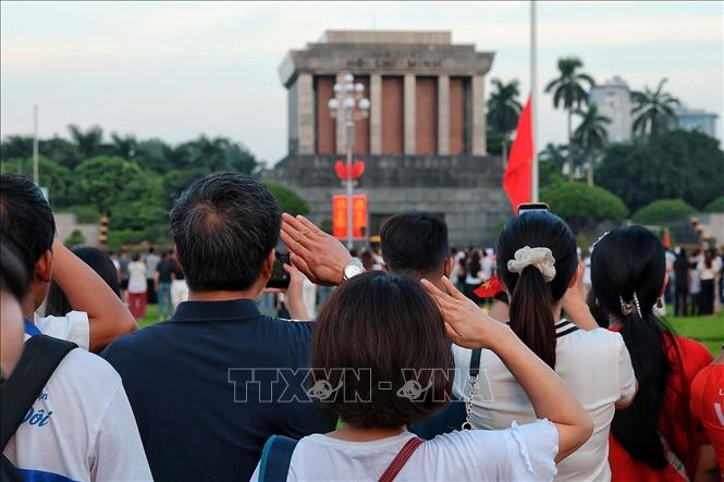 Nhân dân thực hiện nghi thức chào cờ, hướng về Lăng Chủ tịch Hồ Chí Minh trong thời khắc Quốc ca vang lên hùng tráng trên Quảng trường Ba Đình. Ảnh: Phạm Tuấn Anh - TTXVN