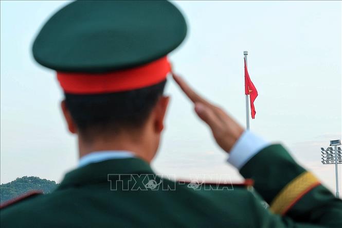 Một quân nhân thực hiện nghi lễ chào Quốc kỳ khi lá cờ đỏ sao vàng được kéo lên trên Quảng trường Ba Đình. Ảnh: Phạm Tuấn Anh - TTXVN