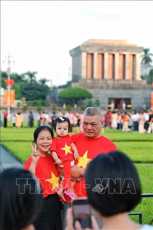 Trong sắc áo cờ đỏ sao vàng, ba thế hệ trong một gia đình cùng lưu lại hình ảnh trước Lăng Chủ tịch Hồ Chí Minh. Ảnh: Phạm Tuấn Anh - TTXVN