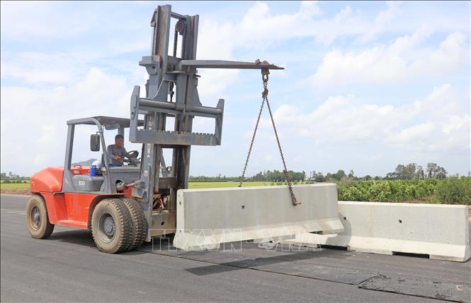 Công nhân Tổng Công ty Xây dựng Trường Sơn lắp đặt, hoàn thiện hệ thống dải phân cách. Ảnh: Công Mạo-TTXVN