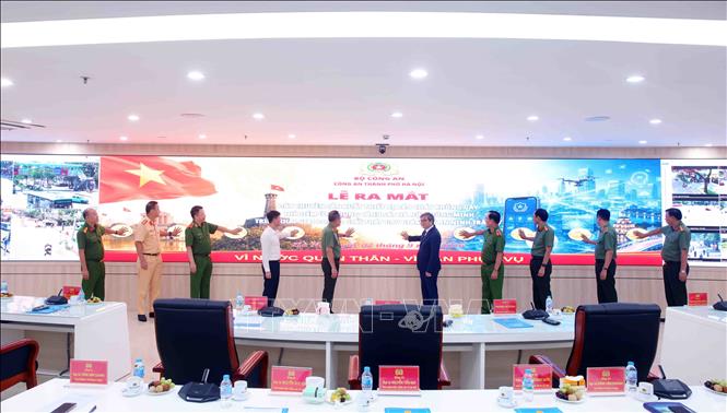 Các đại biểu thực hiện thi thức Lễ ra mắt, giới thiệu dây chuyền sản xuất thiết bị báo cháy không dây; thí điểm ứng dụng Cảnh sát Hà Nội thông minh (Hanoi Smart Police) và triển khai giai đoạn 2 giải pháp UAV giám sát an ninh trật tự. Ảnh: Phạm Kiên - TTXVN