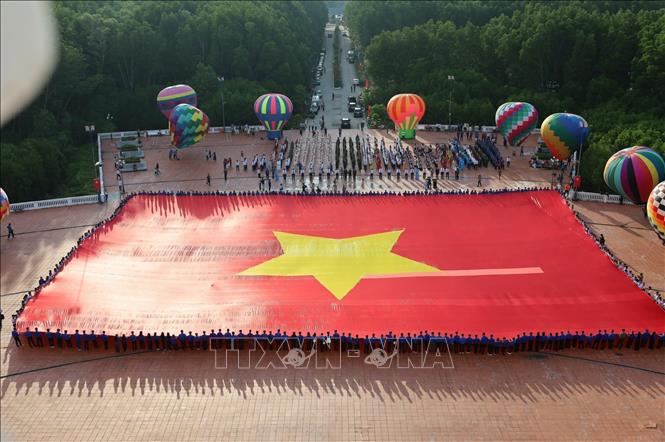 Lá đại kỳ được sử dụng trong Lễ chào cờ đặc biệt có diện tích 2.025m² (chiều dài 60m, chiều rộng 33,75m), trọng lượng khoảng 320kg. Ảnh: Huỳnh Anh - TTXVN