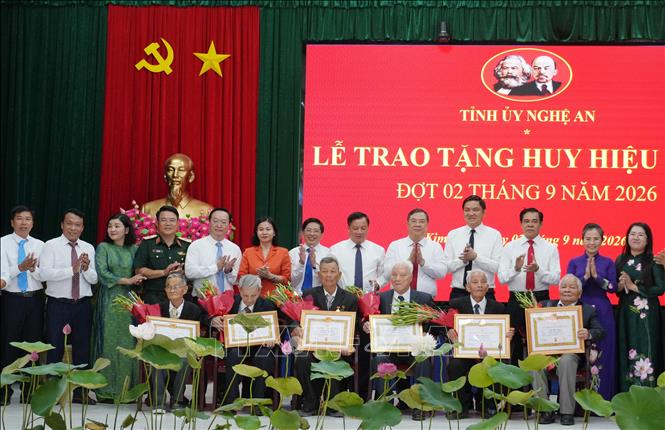 Phó Thủ tướng Thường trực Phạm Gia Túc trao Huy hiệu Đảng cho 6 đảng viên thuộc Đảng bộ xã Kim Liên. Ảnh: Bích Huệ - TTXVN
