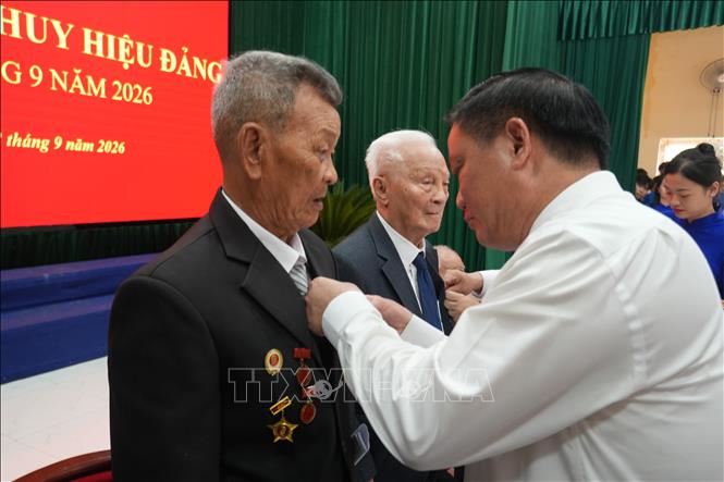 Bí thư Tỉnh ủy Nghệ An Nguyễn Khắc Thận trao Huy hiệu Đảng cho các đảng viên. Ảnh: Bích Huệ - TTXVN