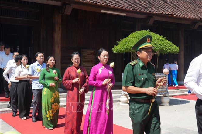Dòng người nối nhau về Khu di tích Quốc gia đặc biệt Kim Liên với những bó sen trên tay mang vẻ đẹp giản dị, thanh khiết và tấm lòng thành kính, biết ơn Người. Ảnh: Bích Huệ - TTXVN