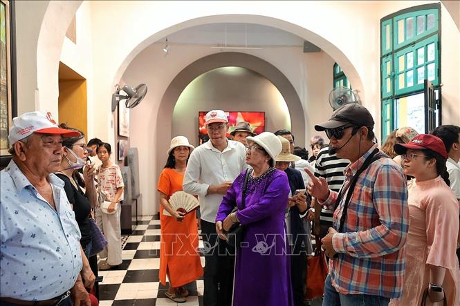 Không gian bên trong Di tích Nhà tù Hỏa Lò đông kín người, nhiều đoàn khách lựa chọn hình thức nghe thuyết minh để hiểu rõ hơn những câu chuyện gắn với từng địa điểm, hiện vật. Ảnh: Phạm Tuấn Anh - TTXVN