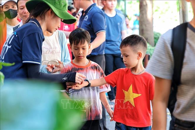 Nhân viên Di tích Nhà tù Hỏa Lò kiểm soát vé, hướng dẫn khách vào tham quan khi lượng người đổ về di tích tăng cao trong ngày 2/9. Ảnh: Phạm Tuấn Anh - TTXVN
