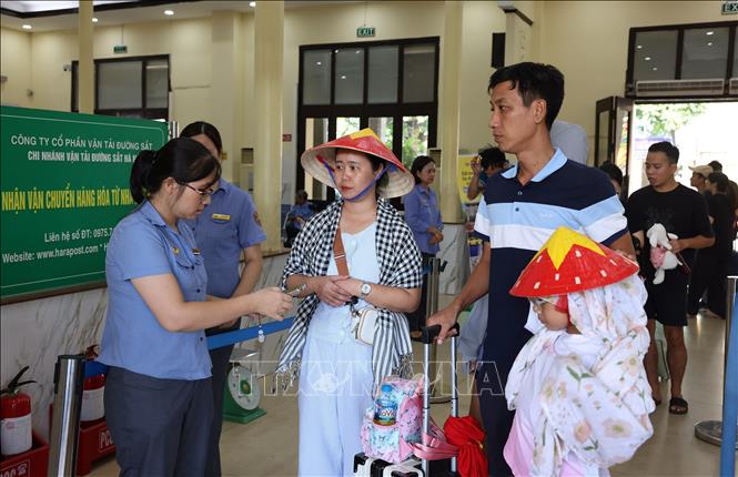 Nhân viên ga Hà Nội kiểm soát vé trước khi lên tàu. Ảnh: Quốc Khánh - TTXVN