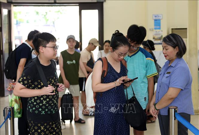 Nhân viên ga Hà Nội kiểm soát vé trước khi lên tàu. Ảnh: Quốc Khánh - TTXVN
