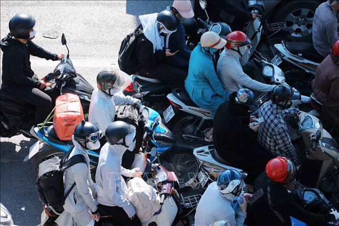 15h30', dù nhiệt độ ngoài trời khoảng 40oC, nhưng lượng người và phương tiện với hành lý, đồ đạc được chằng, buộc cẩn thận di chuyển từ Quốc lộ 1A hướng về trung tâm Hà Nội ngày càng tăng cao. Ảnh: Hoàng Hiếu - TTXVN