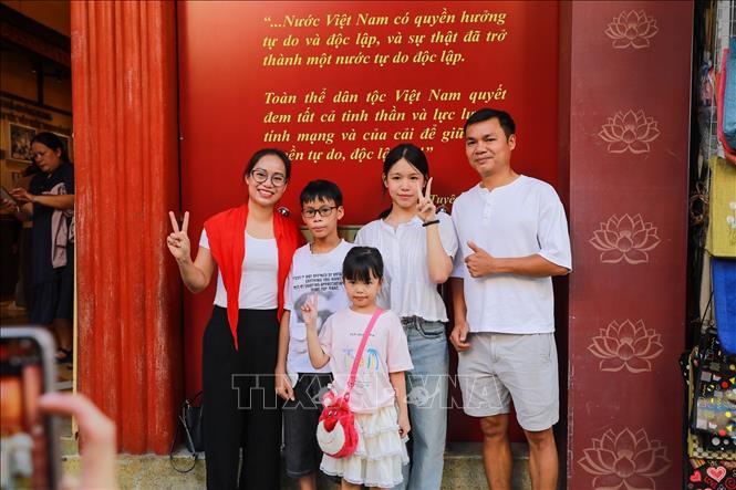 Một gia đình chụp ảnh lưu giữ kỷ niệm tại số nhà 48 Hàng Ngang. Ảnh: Khánh Hoà – TTXVN