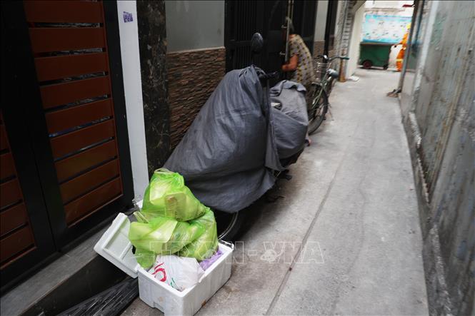 Rác mỗi gia đình được tập kết trước nhà để công nhân vệ sinh đến thu gom. Ảnh: Hồng Đạt - TTXVN