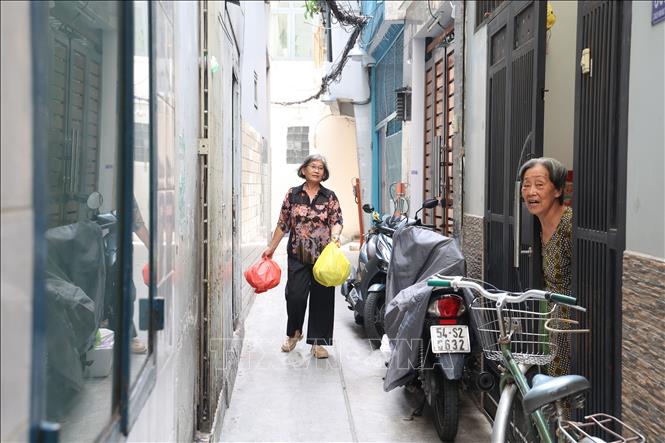 Bà Nguyễn Thị Cẩm Hồng mang rác đi đổ sau khi phân loại. Ảnh: Hồng Đạt - TTXVN