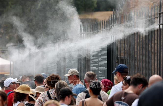 Khách du lịch tránh nóng bên hệ thống phun sương ở Rome, Italy, ngày 26/8/2026. Ảnh: THX/TTXVN phát
