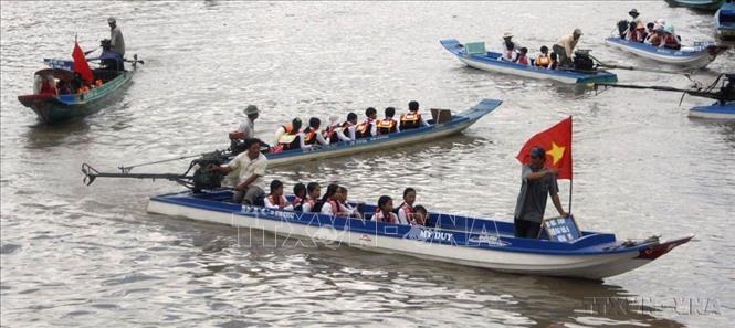 Học sinh Cà Mau đến trường bằng thuyền trong ngày khai giảng năm học mới 2009 - 2010. Ảnh: Lê Huy Hải - TTXVN