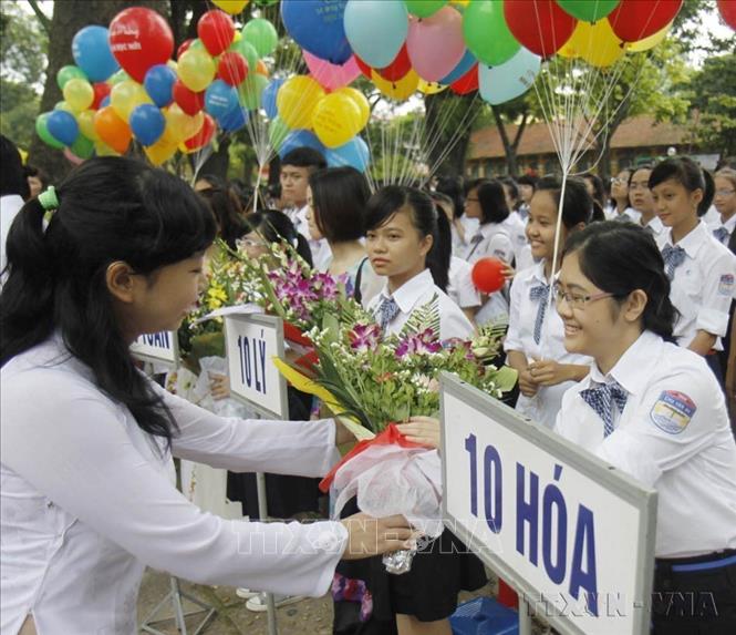 Tặng hoa chúc mừng học sinh lớp 10 Trường THPT Chu Văn An (quận Ba Đình) trong ngày khai giảng năm học mới 2012-2013. Ảnh: Thanh Tùng - TTXVN