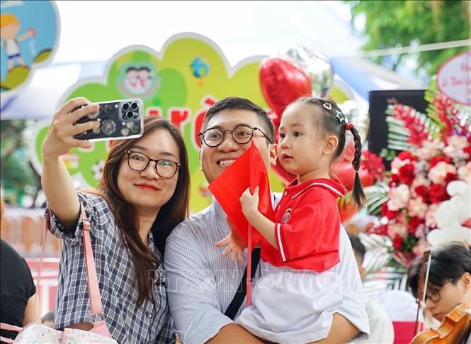  Ngày đầu tiên đi học, bé được cả bố và mẹ đưa tới trường. Ảnh: Khánh Hoà - TTXVN