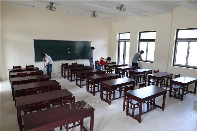 Giáo viên Trường Phổ thông nội trú liên cấp Tiểu học và Trung học cơ sở xã Tây Giang (thành phố Đà Nẵng) dọn dẹp phòng học ở trường phổ thông nội trú liên cấp mới. Ảnh: Khoa Chương - TTXVN