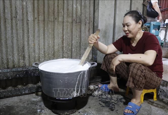 Bột bánh được quấy đều, sánh đặc lại, chín một phần trước khi đem ra gói. Ảnh: Thanh Thương - TTXVN