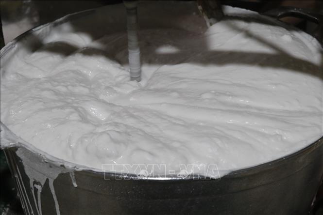 Gạo tẻ sau khi quấy trên bếp tiếp tục được trộn đều cho mịn. Ảnh: Thanh Thương - TTXVN