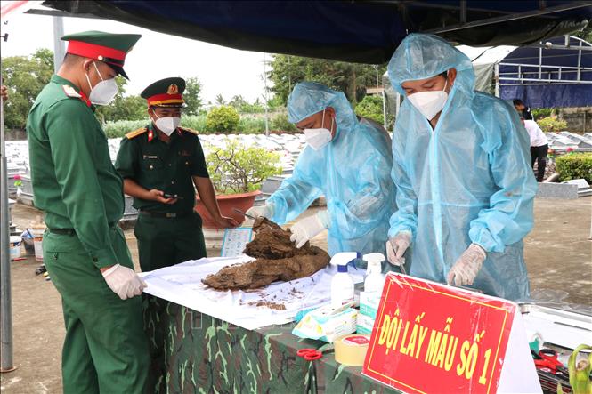 Lực lượng chức năng lấy mẫu hài cốt liệt sĩ chưa xác định được thông tin tại Nghĩa trang Liệt sĩ Tiểu Cần theo đúng quy trình kỹ thuật, phục vụ giám định ADN. Ảnh: Thanh Hòa - TTXVN