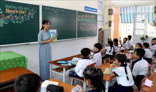 Giáo viên Trường Tiểu học Nguyễn Huệ (phường Long Châu) hướng dẫn học sinh chuẩn bị cho năm học mới. Ảnh: Lê Thúy Hằng – TTXVN