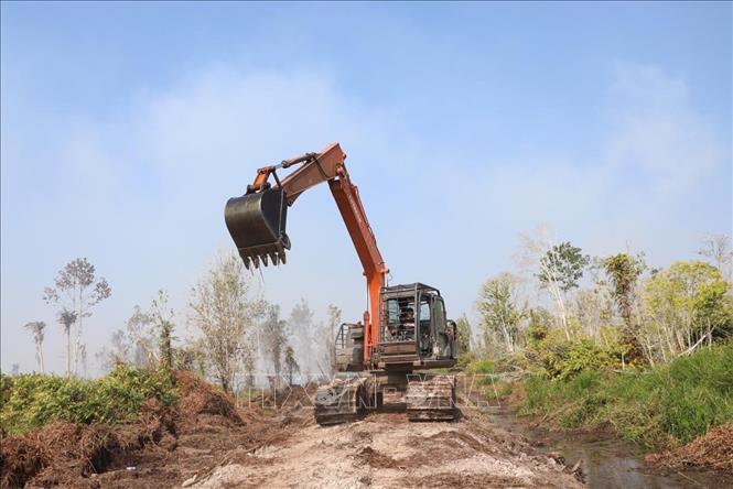 Thiết bị hạng nặng đang tạo các đường ranh cản lửa tại làng Air Merah, huyện Sungai Gelam, tỉnh Muaro Jambi, tỉnh Jambi. Ảnh: TTXVN phát