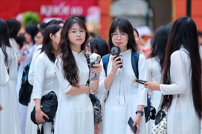 Nữ sinh Trường THPT Việt Đức trong tà áo dài trắng có mặt từ sớm, chuẩn bị tham dự Lễ khai giảng năm học 2026 – 2027. Ảnh: Phạm Tuấn Anh - TTXVN