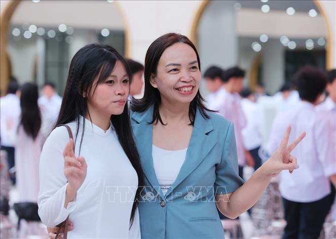 Phụ huynh và học sinh Trường THPT Việt Đức lưu lại kỷ niệm trong ngày đầu tiên của năm học mới 2026 - 2027. Ảnh: Hoàng Hiếu - TTXVN 