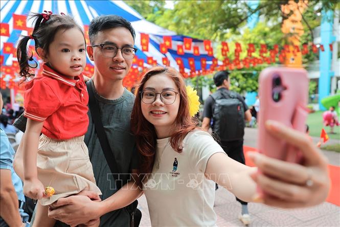 Phụ huynh chụp ảnh lưu niệm cho con trước khi bước vào lớp học tại Trường mầm non Kim Liên (Hà Nội). Ảnh: Lê Đông - TTXVN
