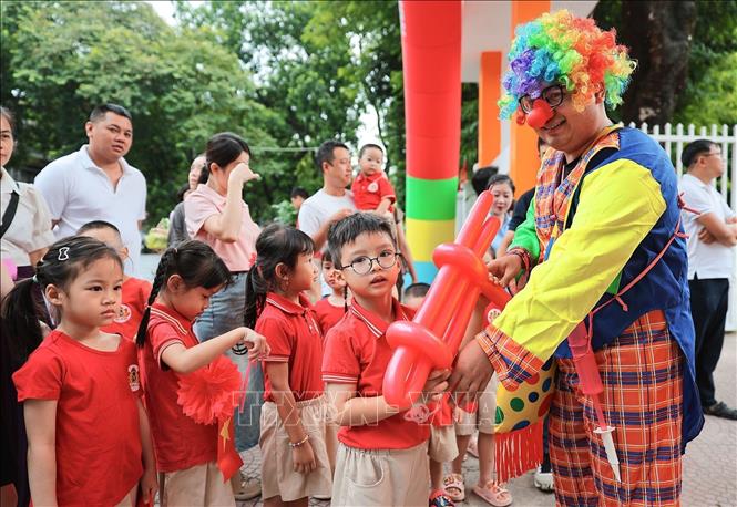 Chú hề tặng bóng tạo không khí vui tươi trong ngày đầu năm học mới tại Trường mầm non Kim Liên (Hà Nội). Ảnh: Lê Đông - TTXVN