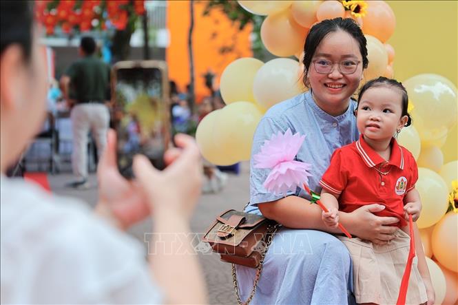 Phụ huynh lưu lại kỷ niệm cùng con trước khi bước vào năm học mới tại Trường mầm non Kim Liên (Hà Nội). Ảnh: Lê Đông - TTXVN