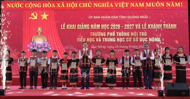 Ủy viên Bộ Chính trị, Giám đốc Học viện Chính trị Quốc gia Hồ Chí Minh Đoàn Minh Huấn và lãnh đạo tỉnh Quảng Ngãi tặng quà cho các em học sinh vượt khó, có thành tích cao trong học tập. Ảnh: Cao Nguyên - TTXVN