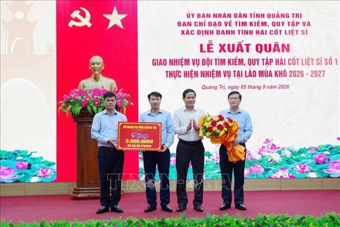 Lãnh đạo Sở Ngoại vụ tỉnh Quảng Trị tặng quà động viên Đội tìm kiếm, quy tập hài cốt liệt sĩ số 1 lên đường thực hiện nhiệm vụ. Ảnh: TTXVN phát