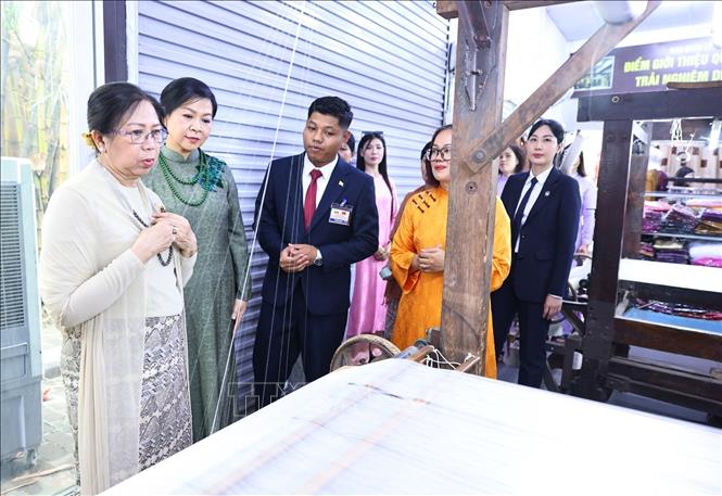 Ms. Ngo Phuong Ly and Ms. Kyu Kyu Hla view Van Phuc's artisans performing silk weaving skills. VNA Photo: Minh Đức
