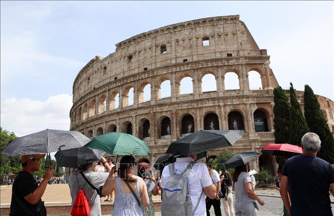 Khách du lịch che ô tránh nắng nóng tại Rome, Italy. Ảnh: THX/TTXVN phát