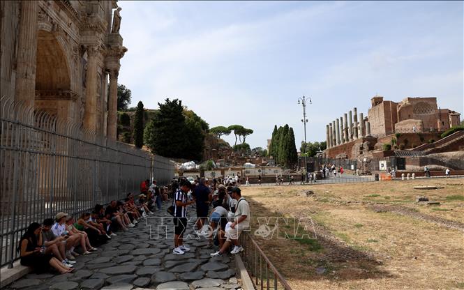 Khách du lịch tránh nóng dưới bóng râm tại Rome, Italy. Ảnh: THX/TTXVN phát