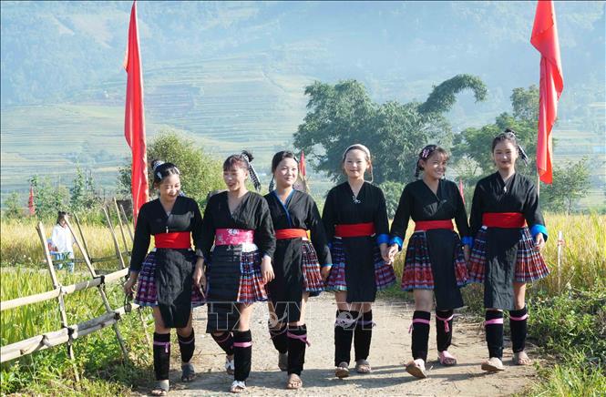 Thiếu nữ Mông với trang phục truyền thống đi chơi Ngày hội “Mùa vàng Tả Lèng - Hương lúa giữa non cao”. Ảnh: Nguyễn Oanh - TTXVN
