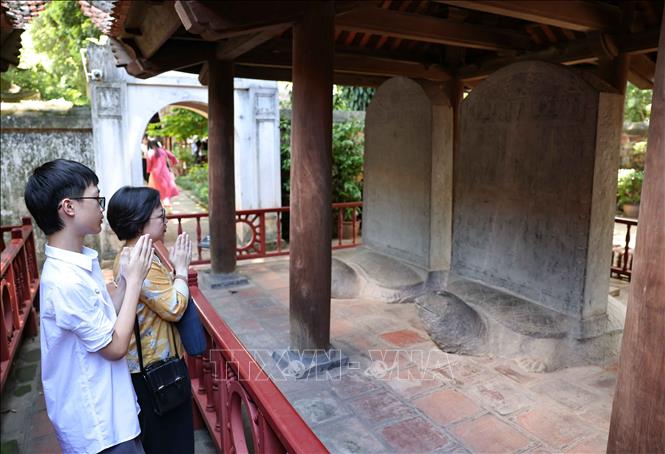 Con cháu dòng họ Nguyễn Đông Tác bên văn bia lưu danh Hoàng giáp Nguyễn Trù ở Văn Miếu - Quốc Tử Giám (Hà Nội). Ảnh: Thanh Tùng - TTXVN 